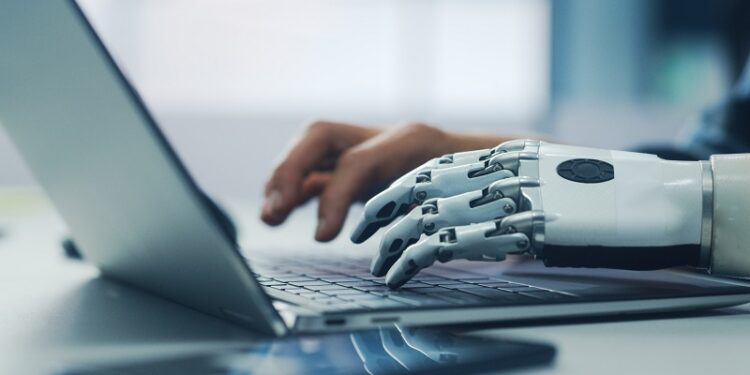 Close-up on Hands: Person with Disability Using Prosthetic Arm to Work on Laptop Computer. Specialist Swift and Natural Use of Thought Controlled Body Powered Myoelectric Bionic Hand.